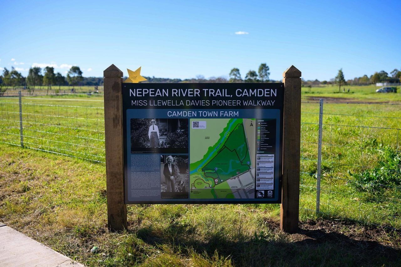 Sign on a pathway with grass field in background