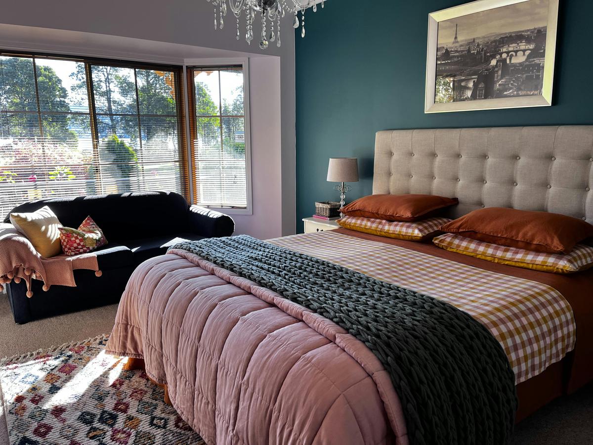 Dreamy bedroom of The Waterview apartment with KS bed and views over the garden to Cygnet Bay