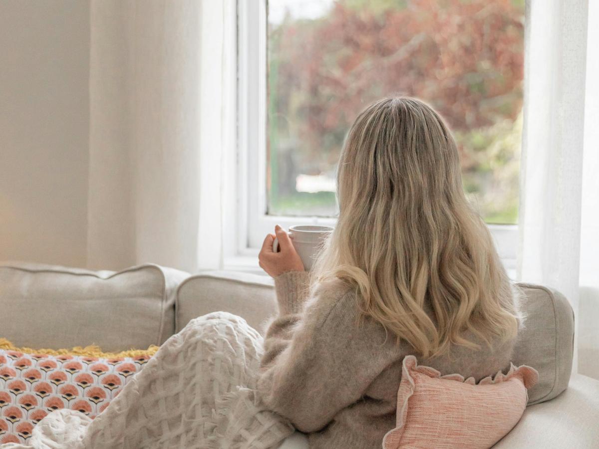 Woman enjoying coffee and view over garden