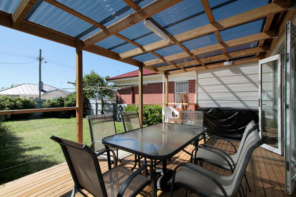 Undercover patio/BBQ area overlooking secure fenced lawn/play area.