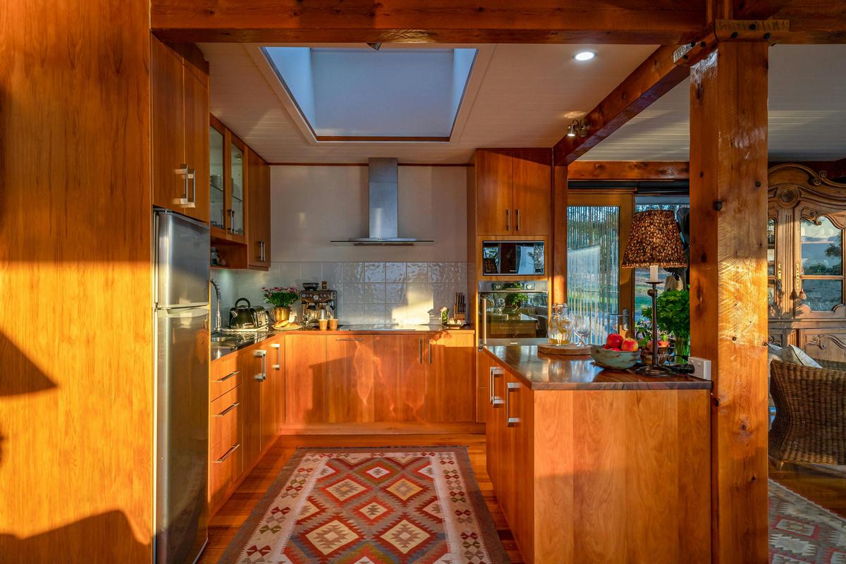 A photo of the Huon River Hideaway kitchen featuring custom timber cabinetry and ample appliances