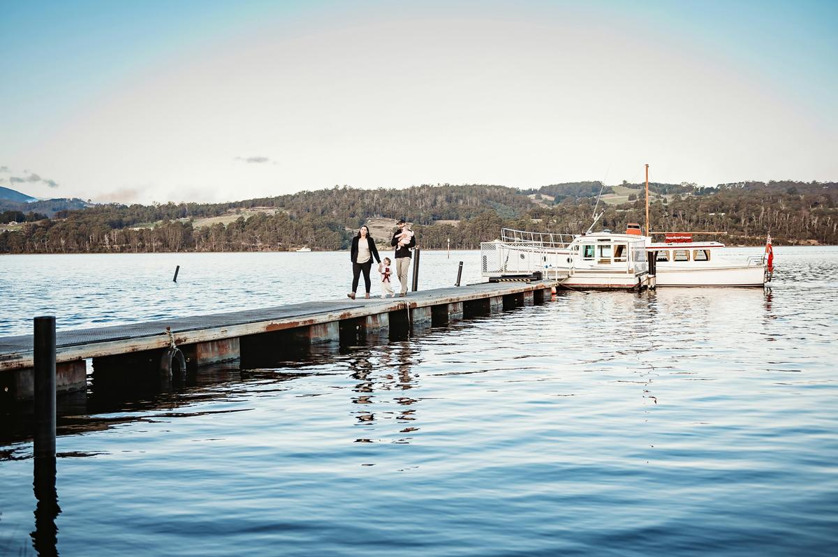 A Beautiful young family walking up the dock after a cruise on the Huon River