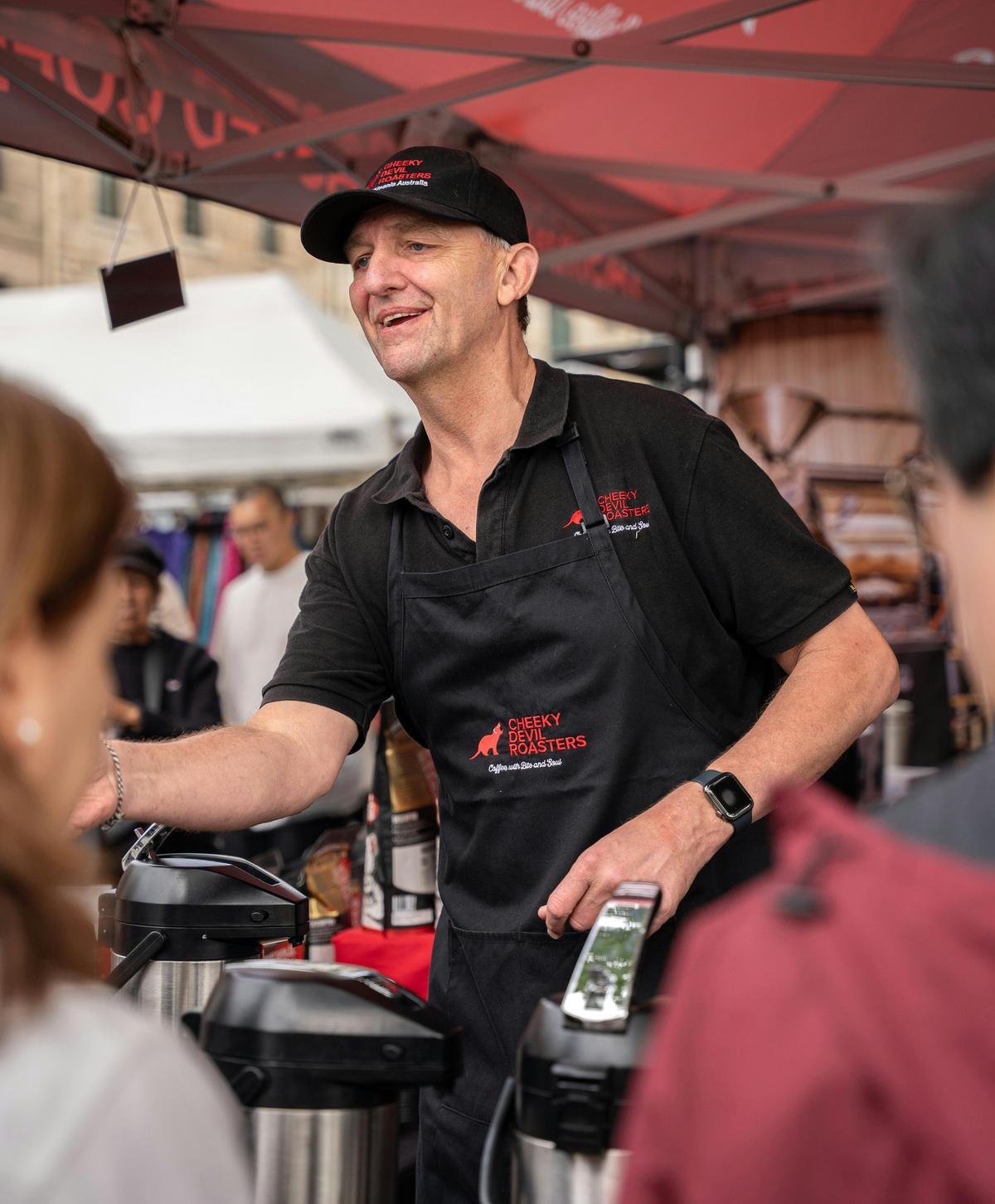 Serving freshly made coffee at the Cheeky Devil Salamanca Market stall.
