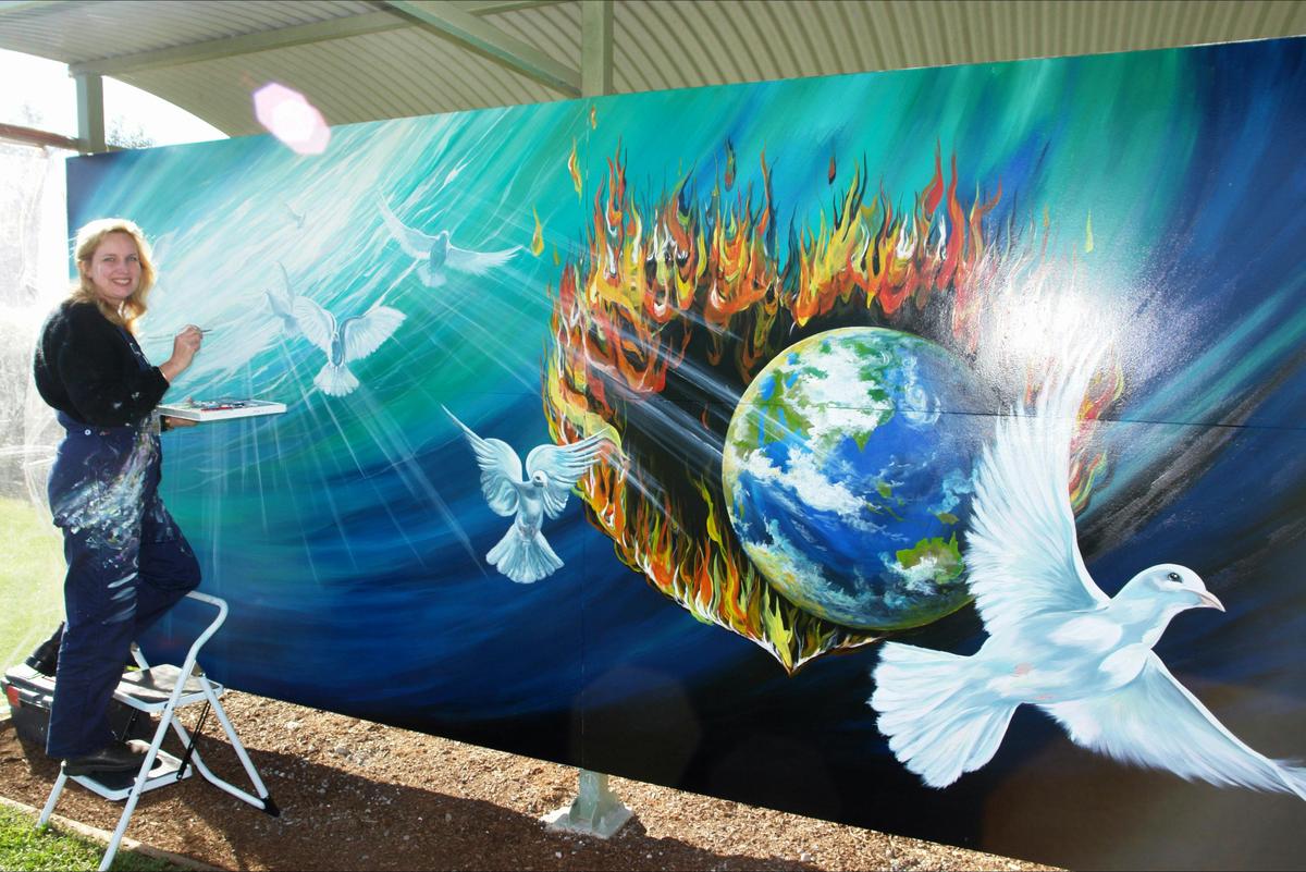An International Mural Fest entrant paints her mural during the annual competition.