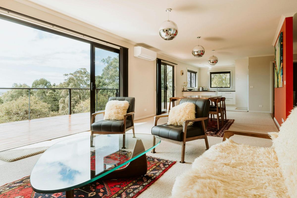 Bright, spacious living, dining, and kitchen flowing onto the balcony with panoramic vistas.