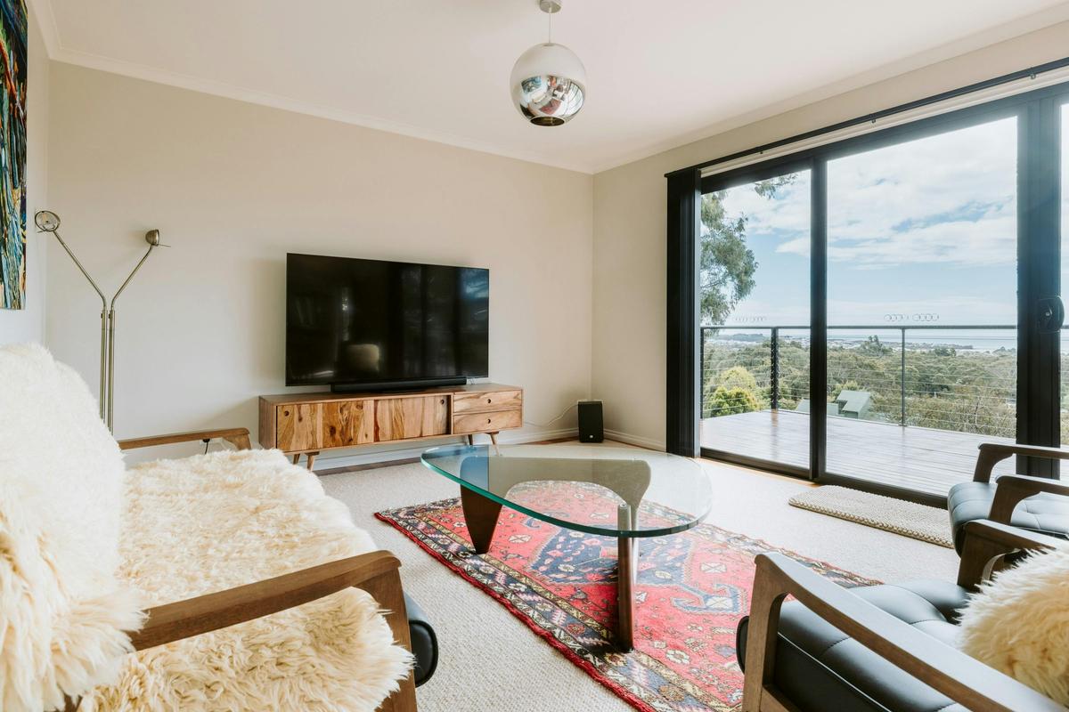 Stylish living space with 65-inch smart TV, sound system, and seating for up to 5.