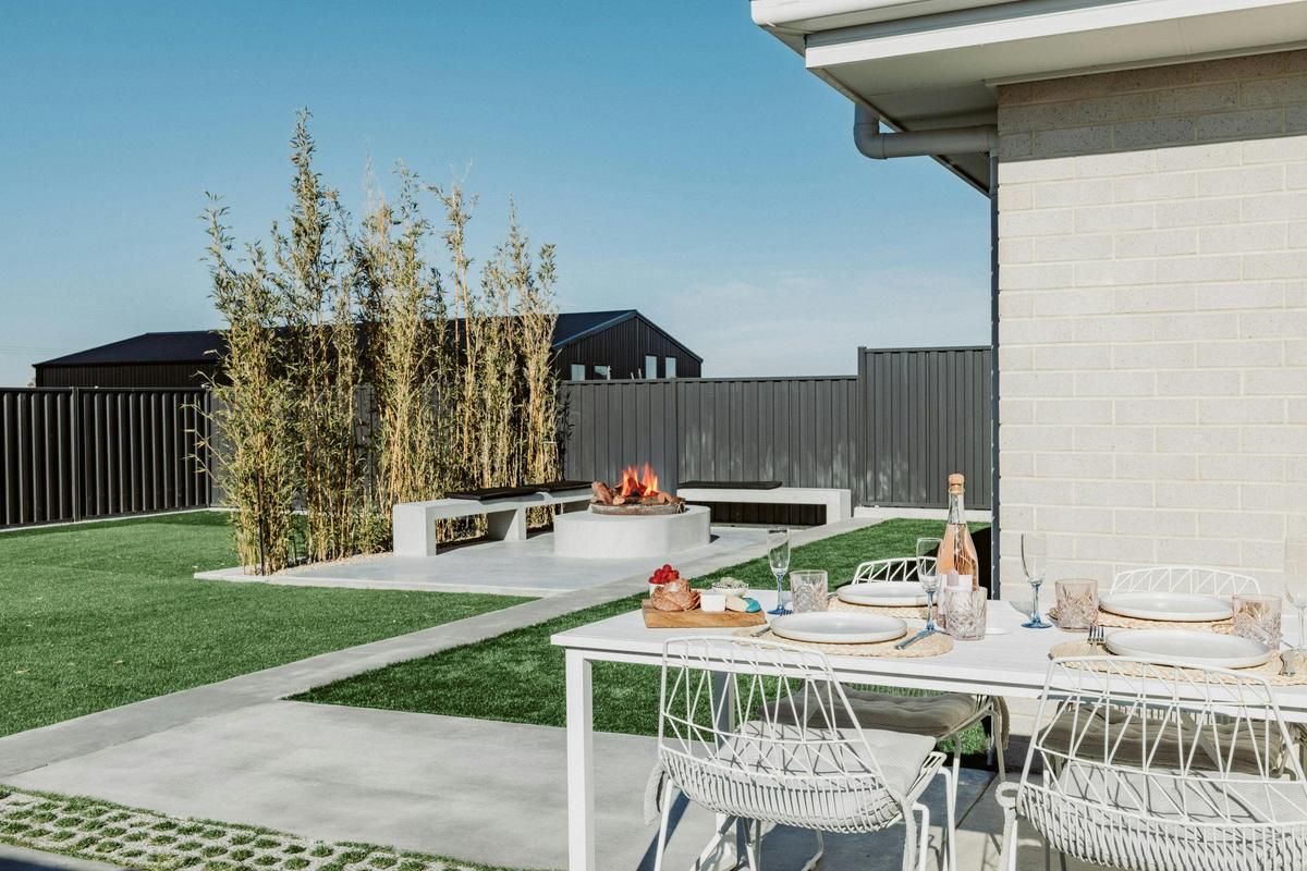 The backyard has a 6-seater dining table, firepit, and plenty of space for the kids to run around.