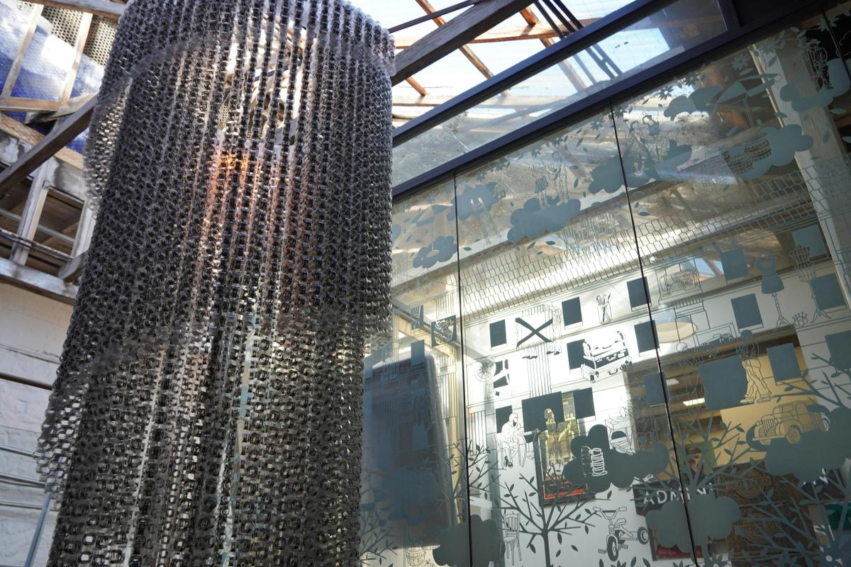 An art installation that looks like a chandalier hanging in the historic rafters