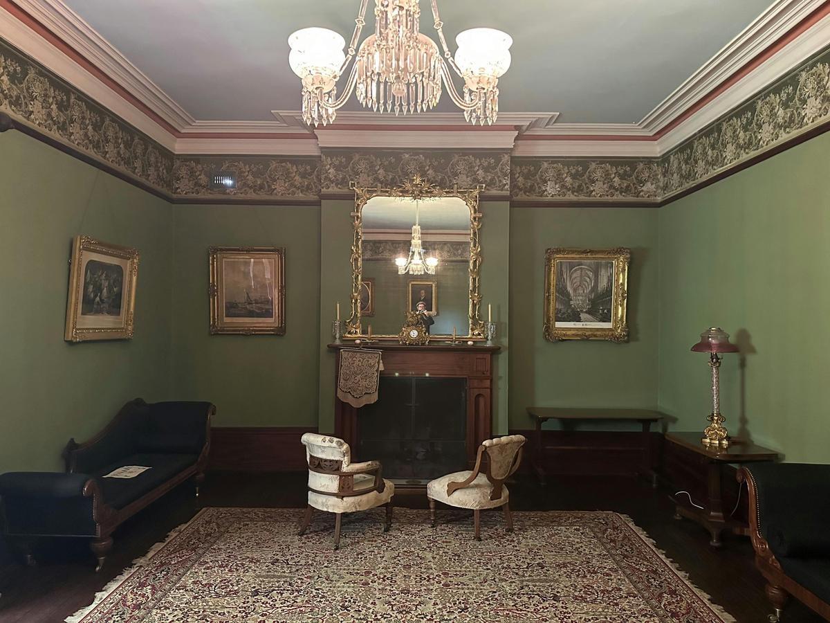 The Drawing Room at Runnymede features a magnificent bay window, ornate mirrors, and a grand piano.