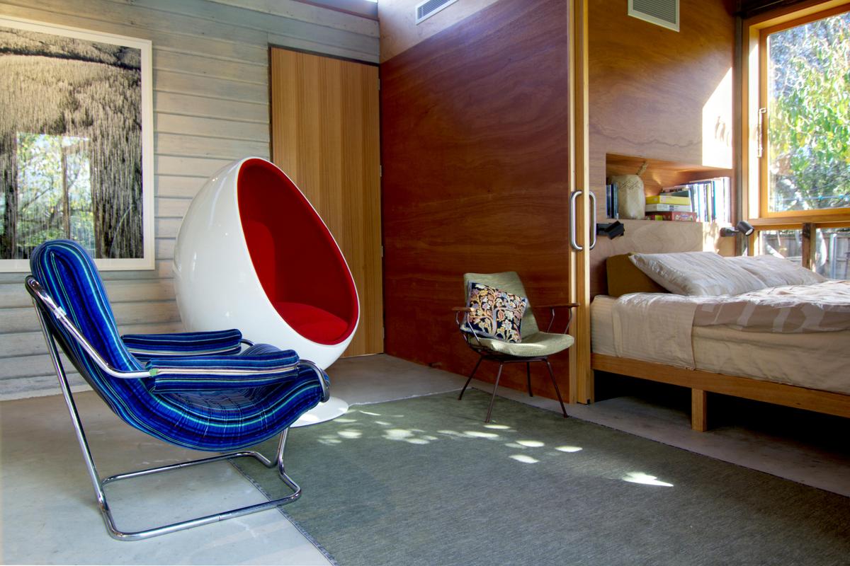 Living area with a collection of midcentury modern furniture and bed alcove