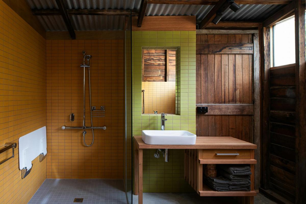 accessible bathroom with textured timber walls and bright coloured tiles