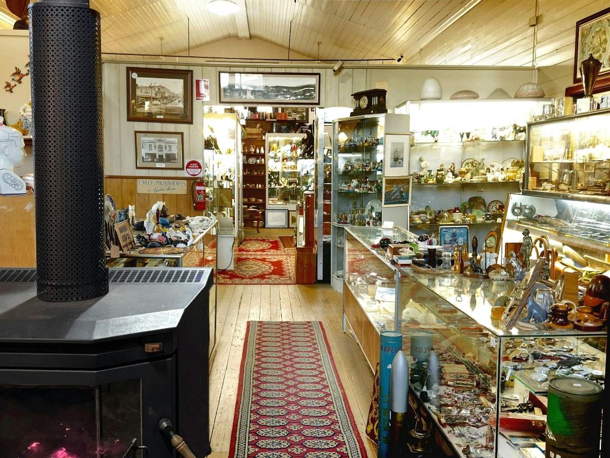 Cosy front gallery with wood heater, Tasmanian timber furniture and vintage collectables