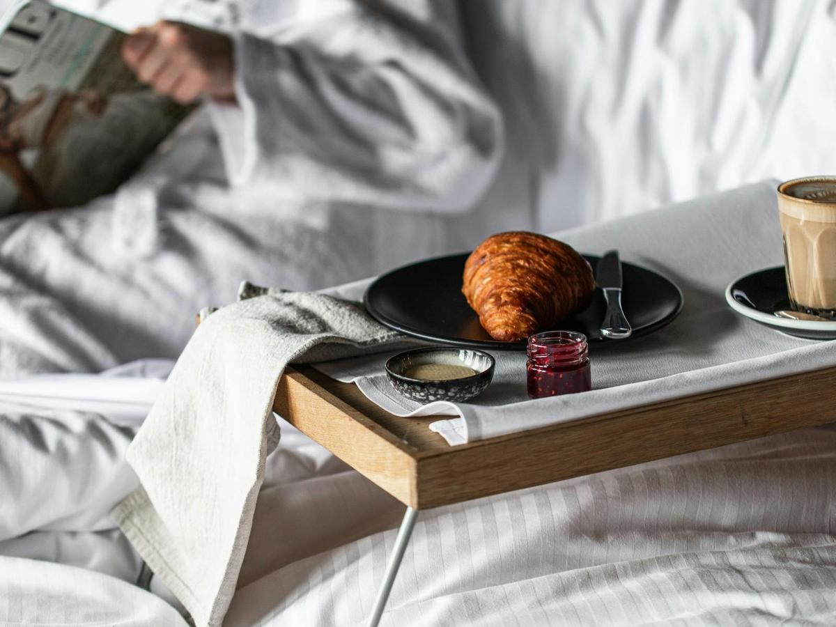 Breakfast in bed with fresh croissants and a coffee