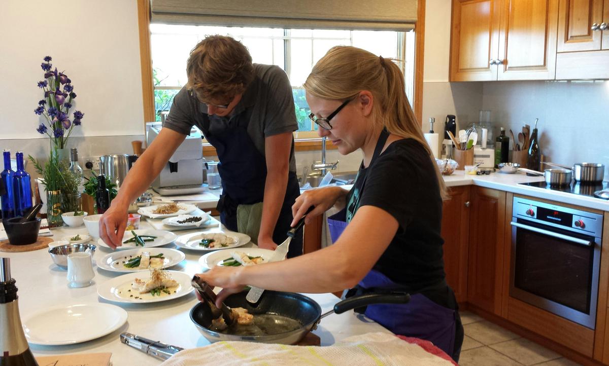 Cooking Class couple from Europe preparing dishes in Sylvia's Sensational Seafood Class