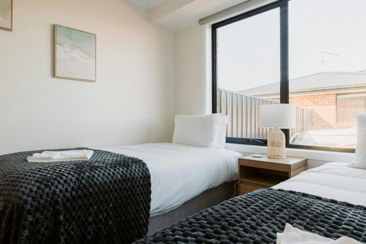 Second bedroom is light-filled, with two king single beds and a charging pad for your devices.
