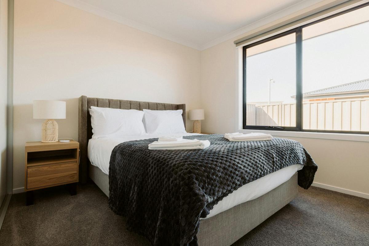 Third bedroom includes a queen bed, sliding wardrobe, heater, and charging pads for convenience.