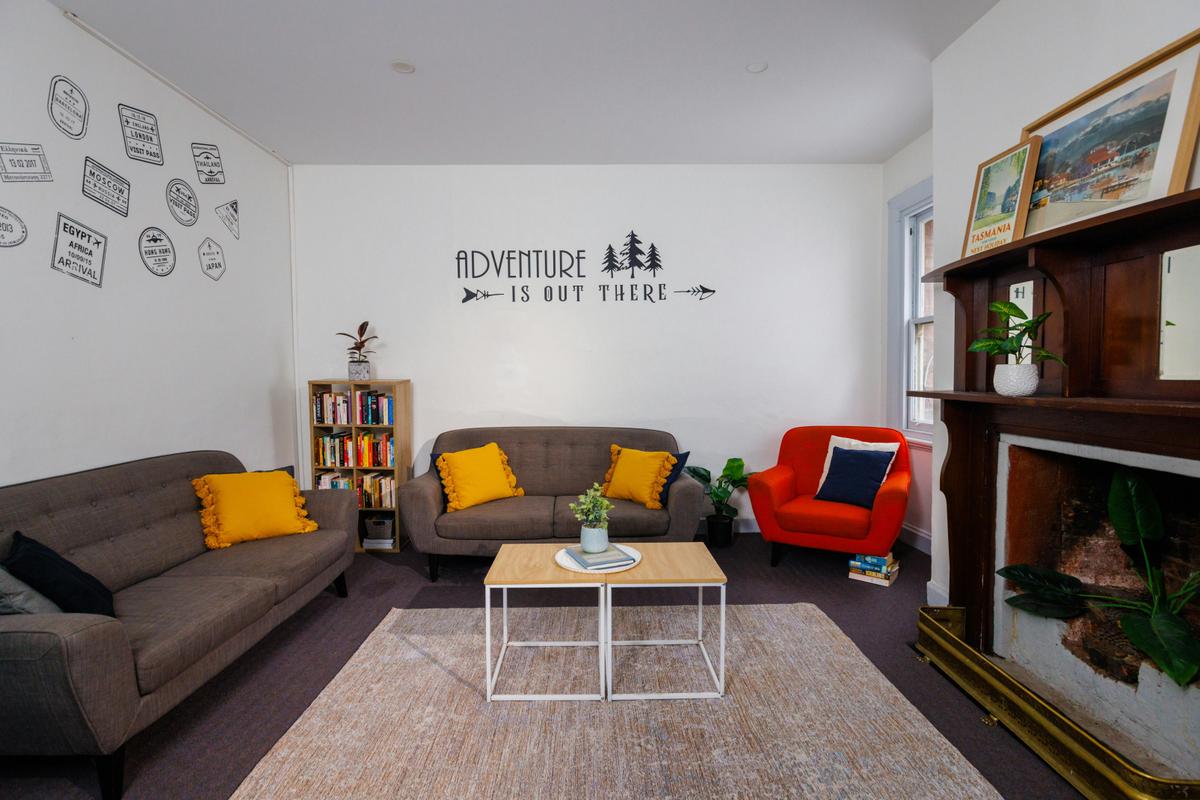 Lounge room with couches and colourful cushions at YHA Hobart Central