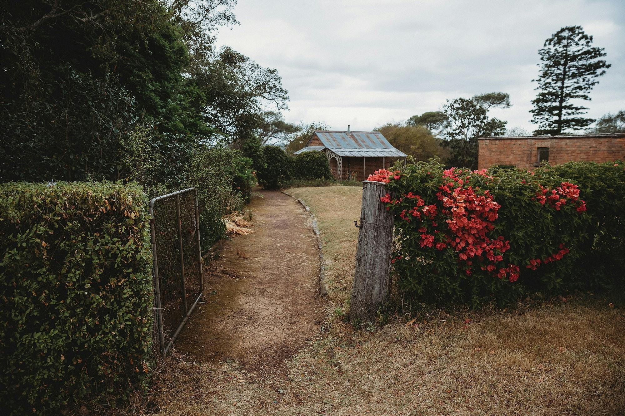 Path with flowers on fence leading to historic building