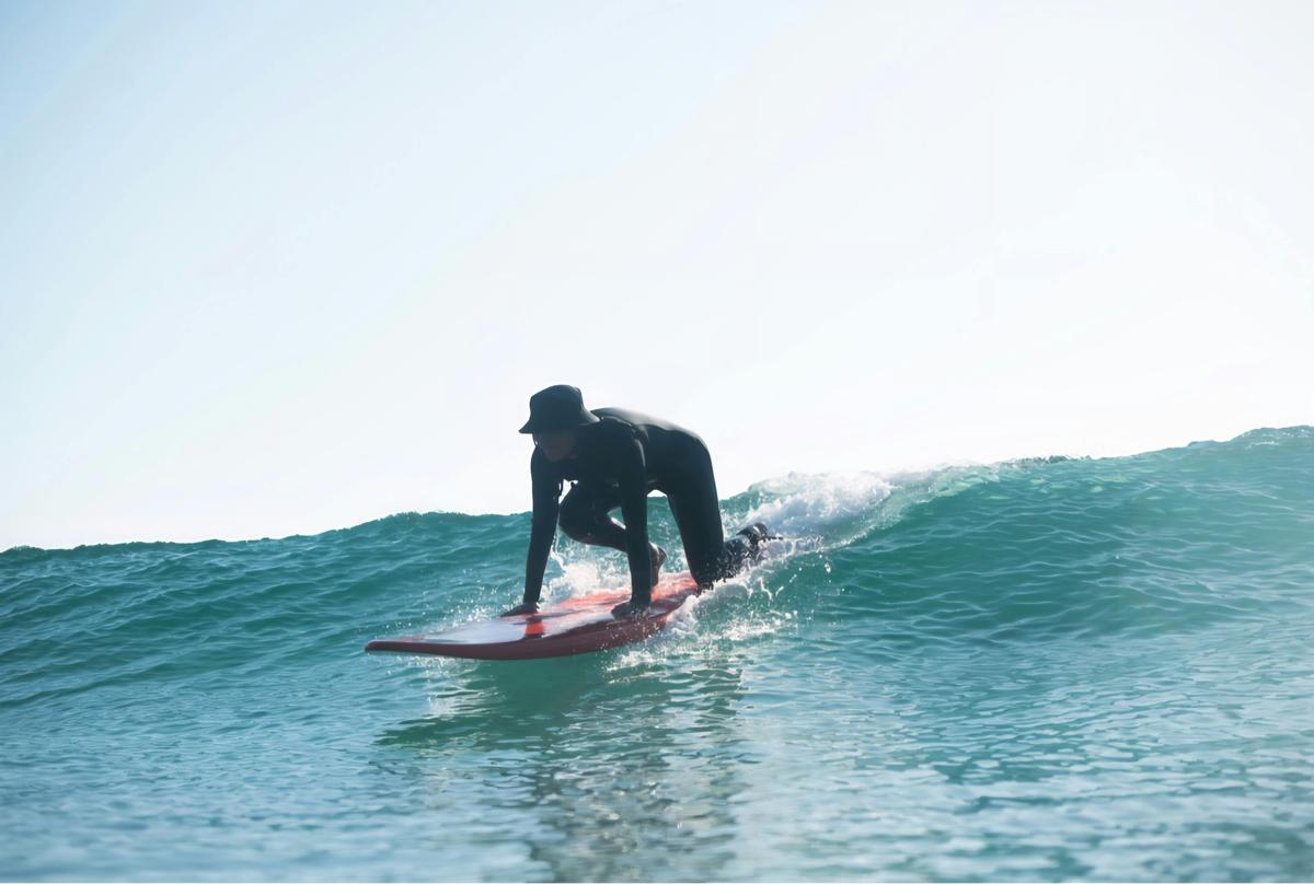 Beginner surfer taking off on a wave.