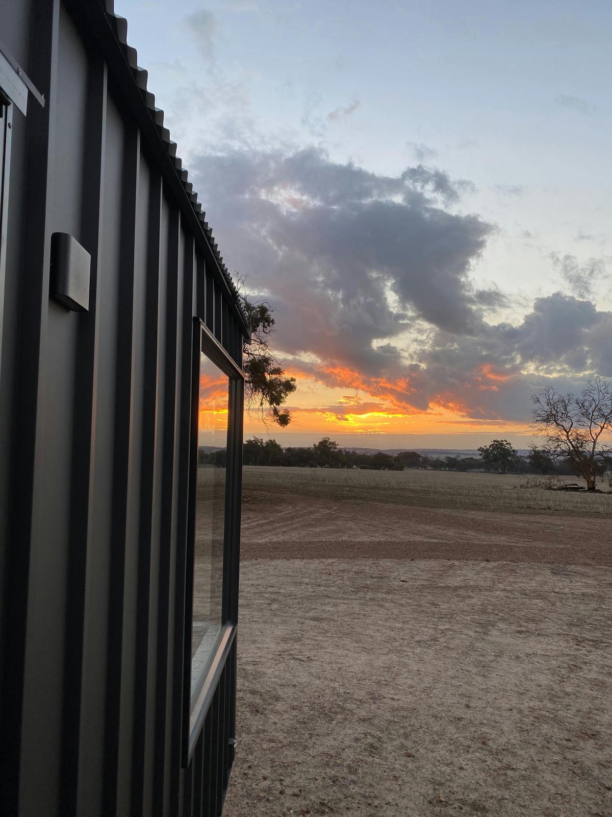 Showcasing the view of the sunset from the deck, the bed alos faces this way