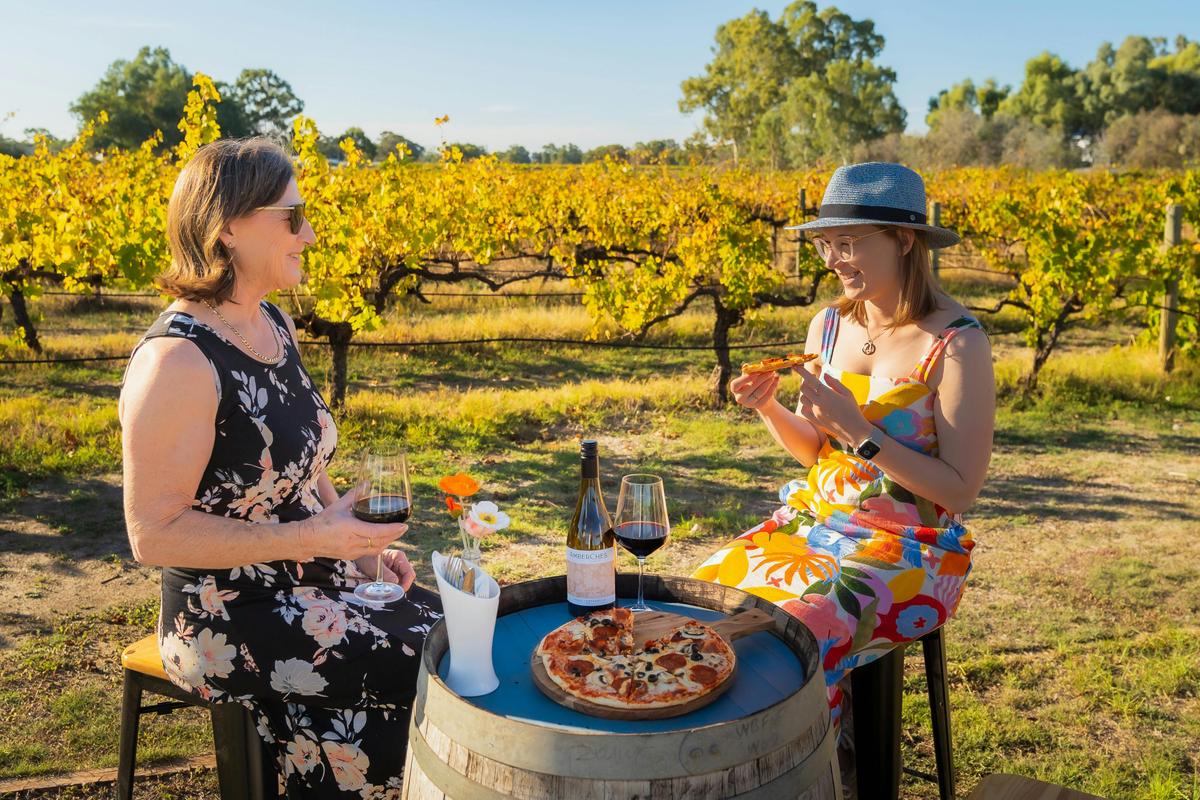 Guests enjoying pizza and drinks at AmberChes Spirits Distillery in the Swan Valley