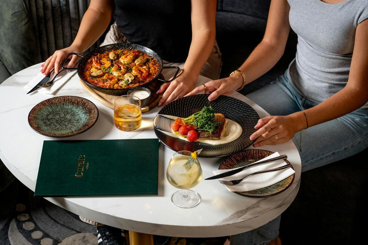 people sitting at a table with food in front of them