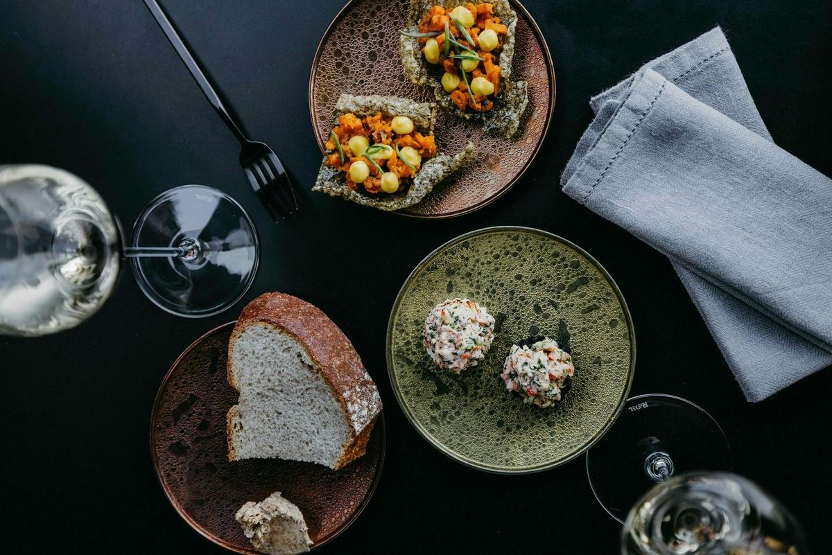 Snack (L) Exmouth prawn salad, charcoal brioche, sweet corn. Snack (R) organic carrots tartare, kelp