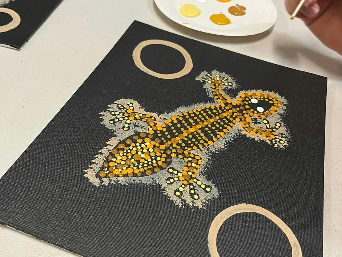Fiona Reidy holding their Aboriginal artwork painting
