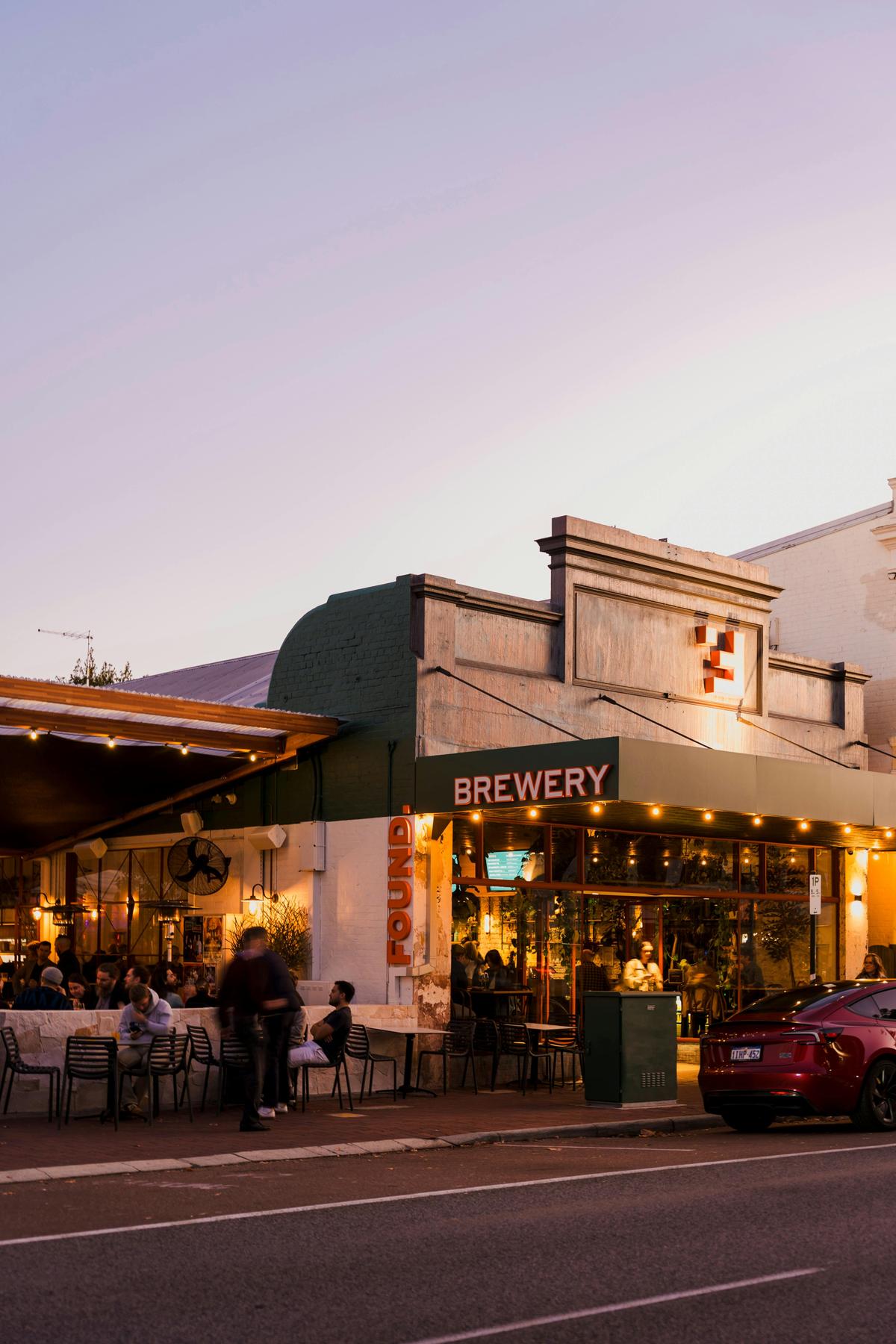 Found Brewery Subiaco exterior at dusk, with warm string lights, outdoor seating area with guests,