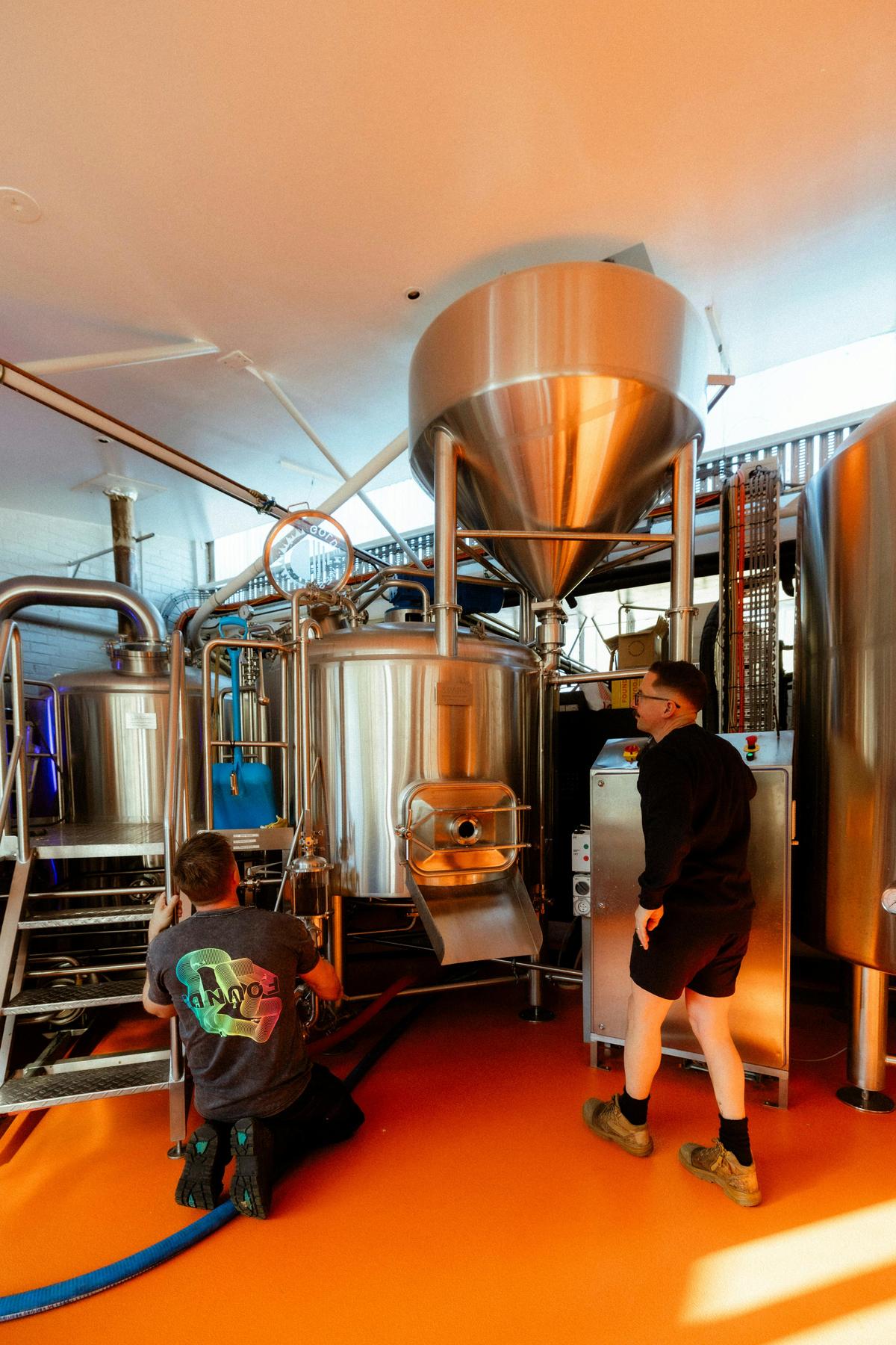 Two brewers working alongside stainless steel brewing tanks at Found Brewery Subiaco.