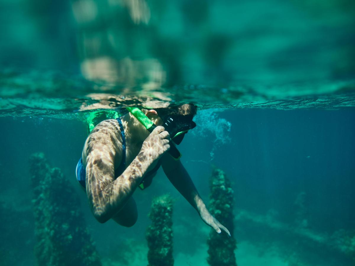 Close-up of a girl snorkelling, above a shipwreck.