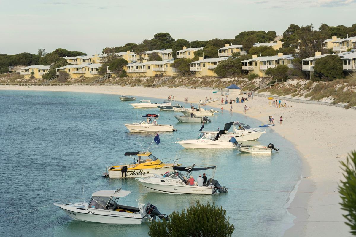 Several boats anchored off the beach of a large bay