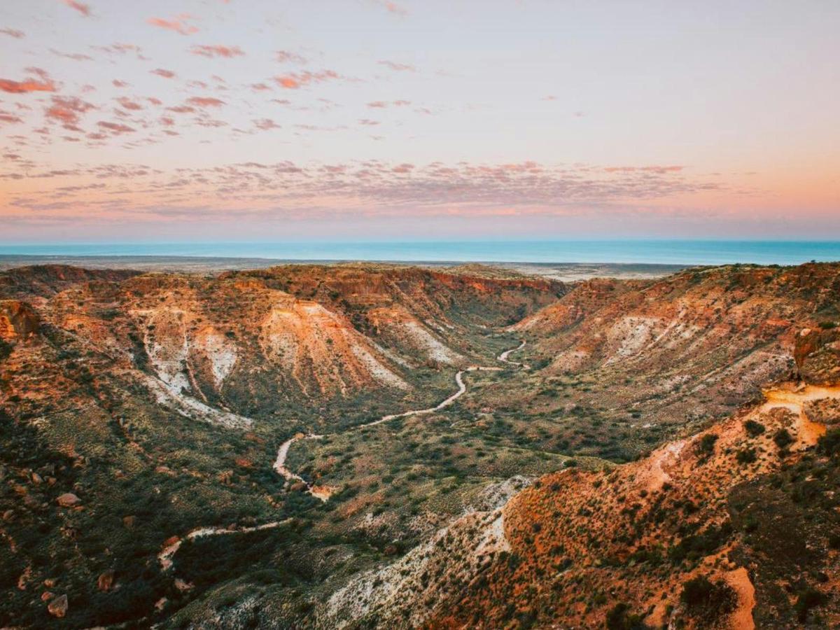 Charles Knife Canyon glowing with orange and pink hues at sunrise.