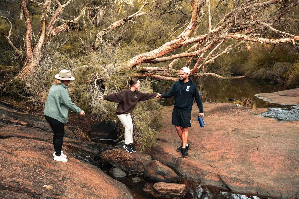 People on rocks with water in background