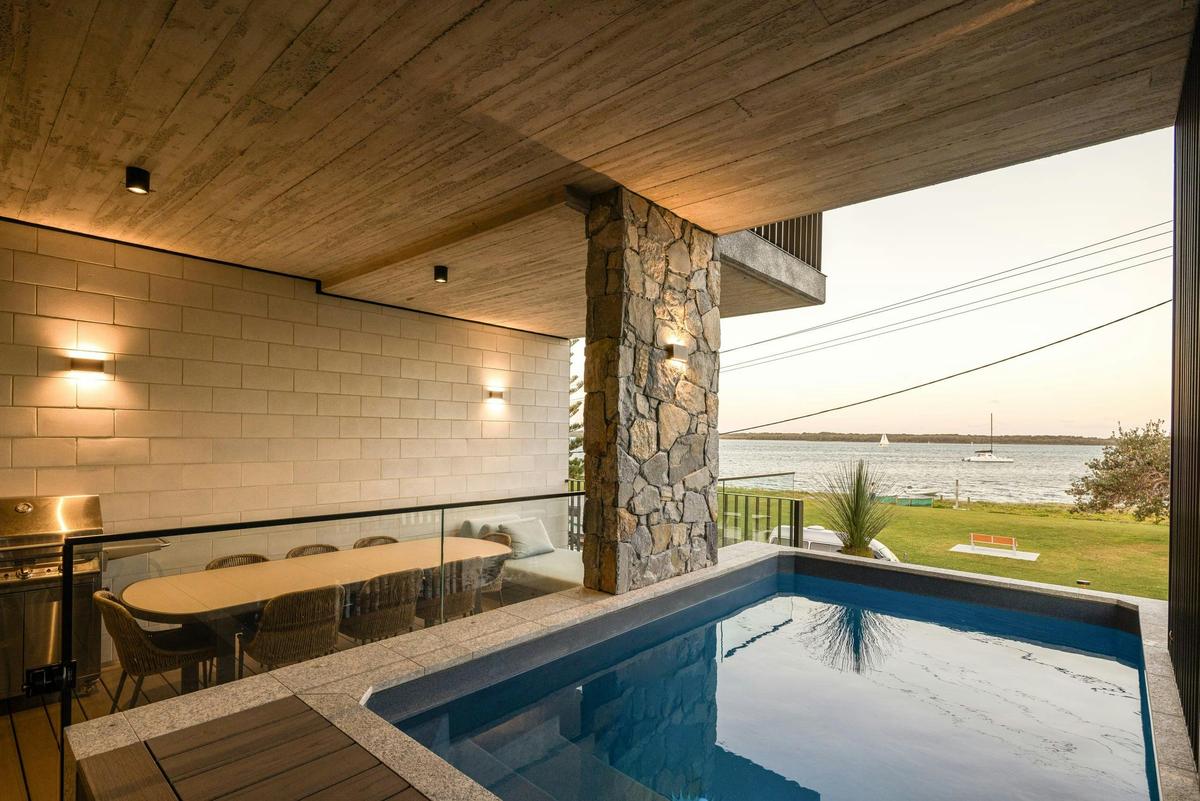 Covered terrace on the broadwater, heated spa alongside, the table set for 10
