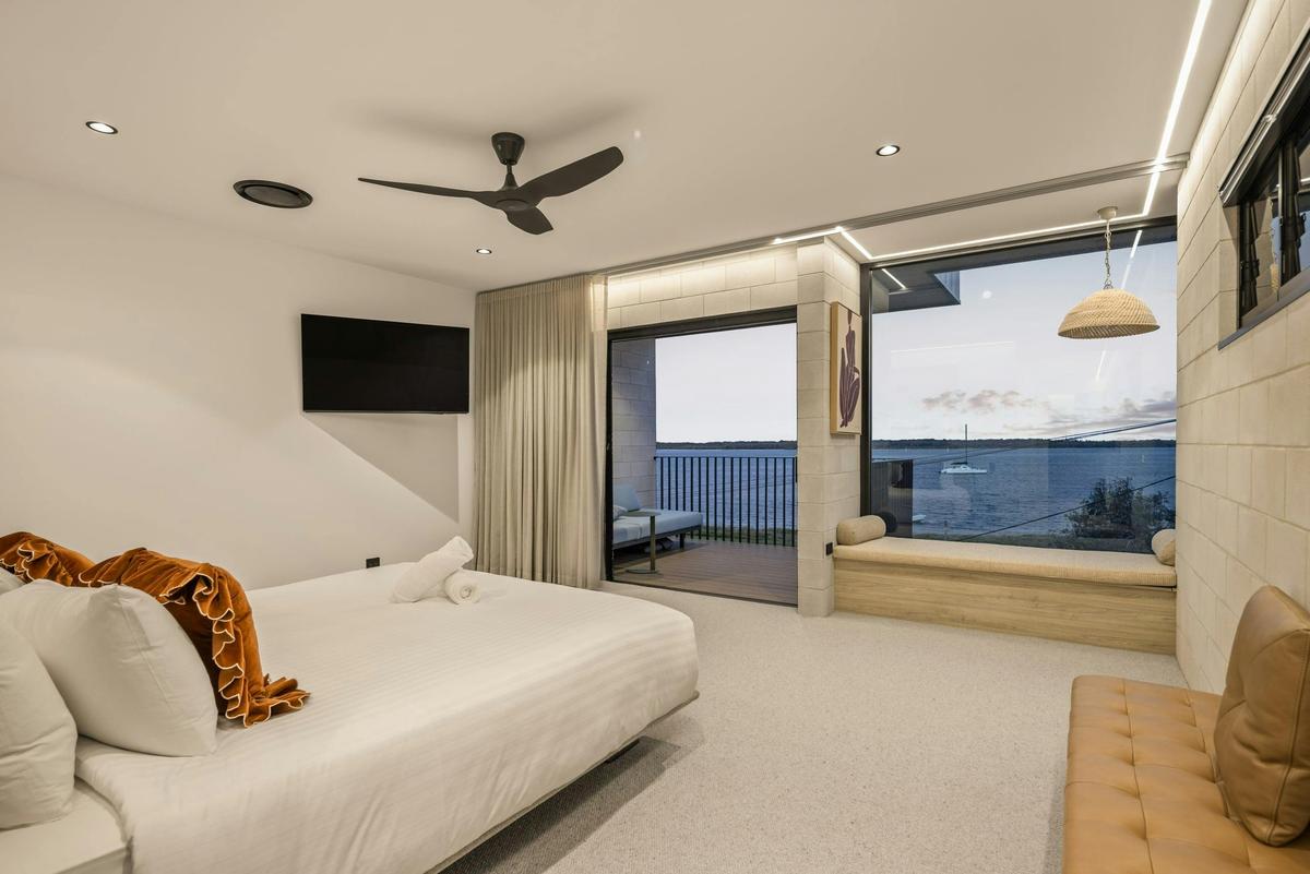 Main bedroom looks straight out to the water, window seat under the glass