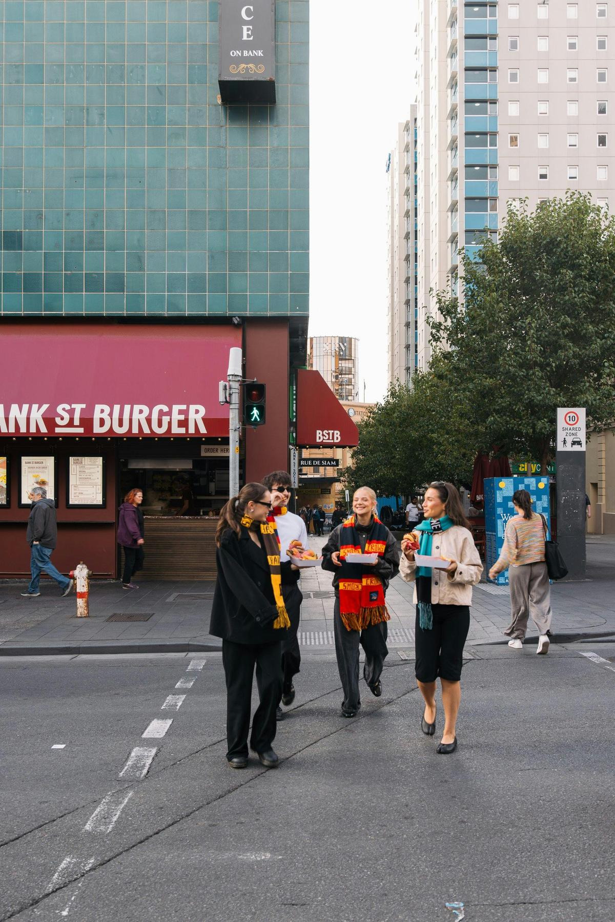 Four People Happily cross the road with Bank Street Burger in the background