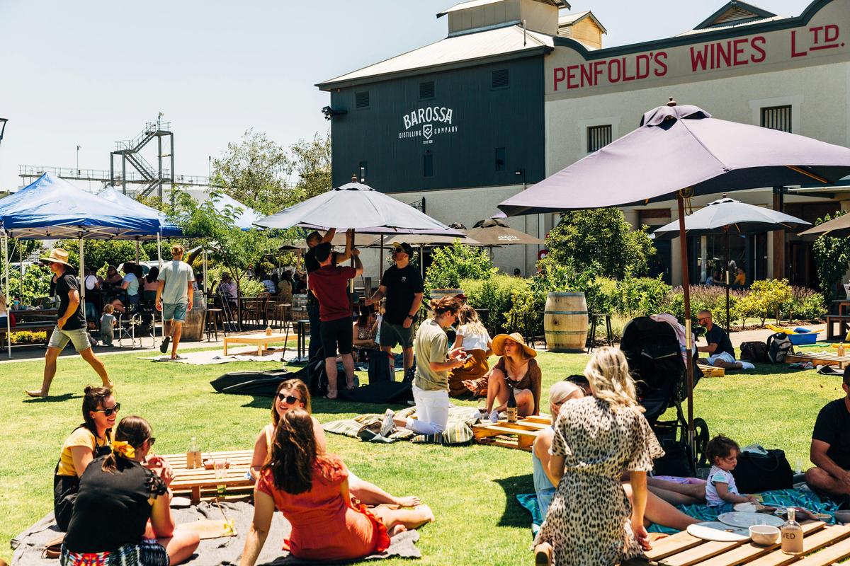Exterior photo of the Distillery Bar with people relaxing with drinks and food on the lawn