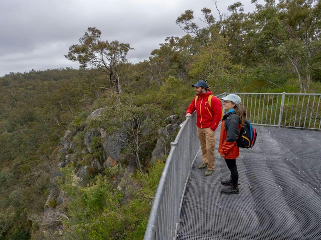 Two people standing taking in the view from The Lookdown lookout in Bungonia National Park. Photo: