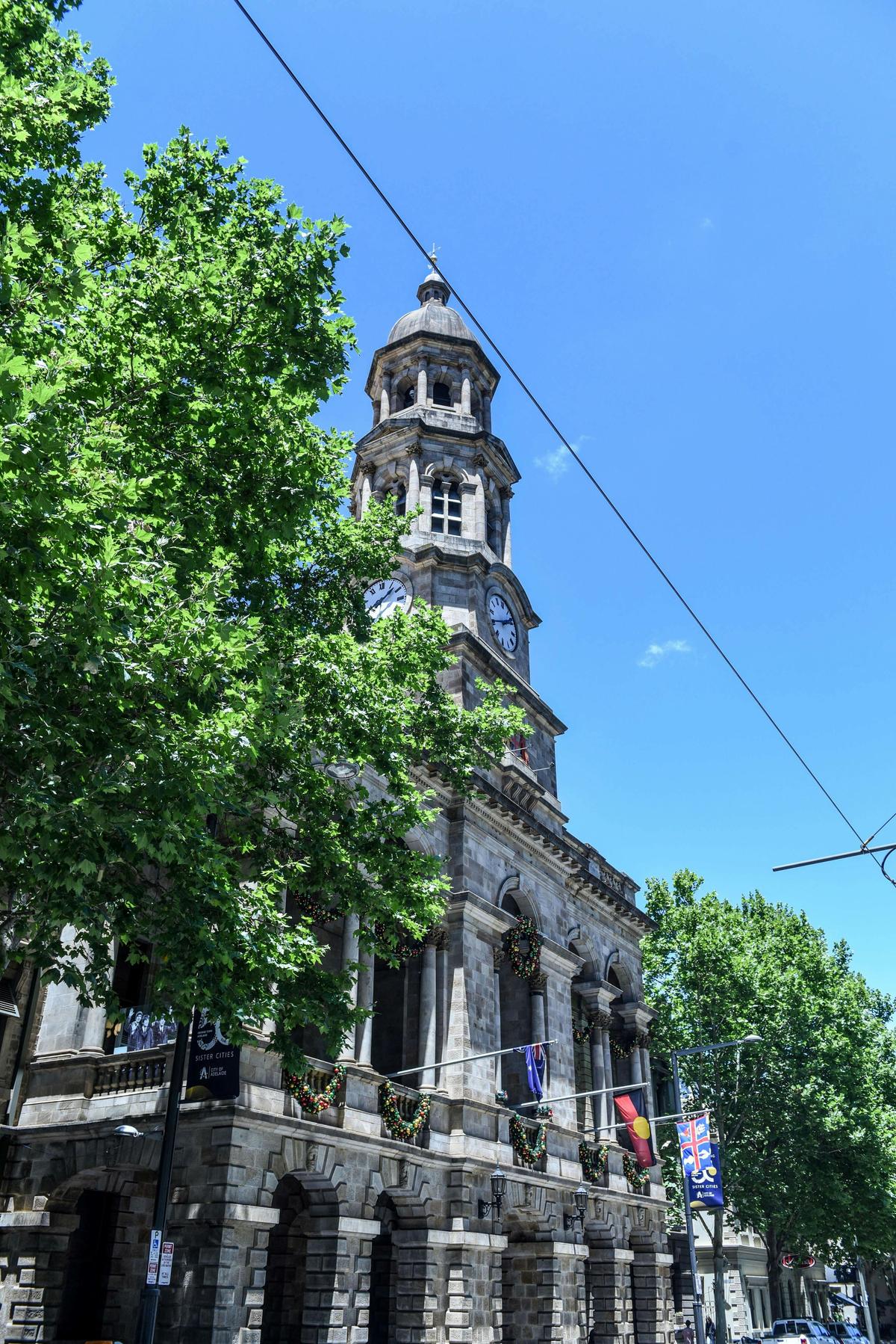 View of Adelaide Town Hall from outside. Historic building in tree lined street