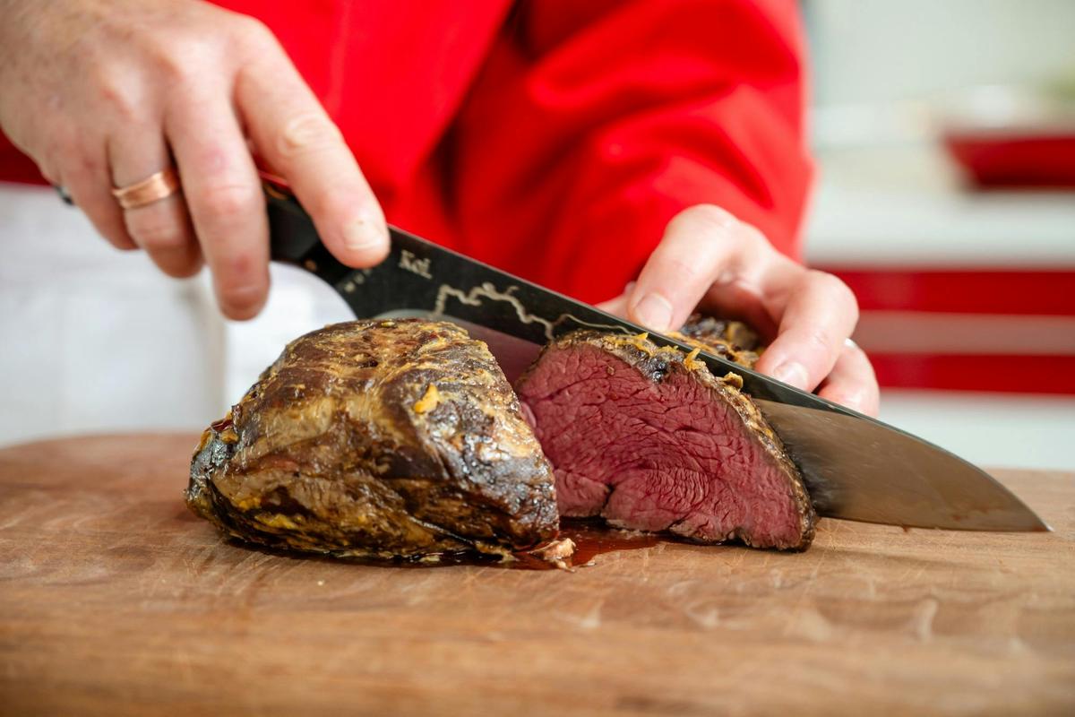 Perfectly cooked beef fillet being carved during a gourmet cooking class