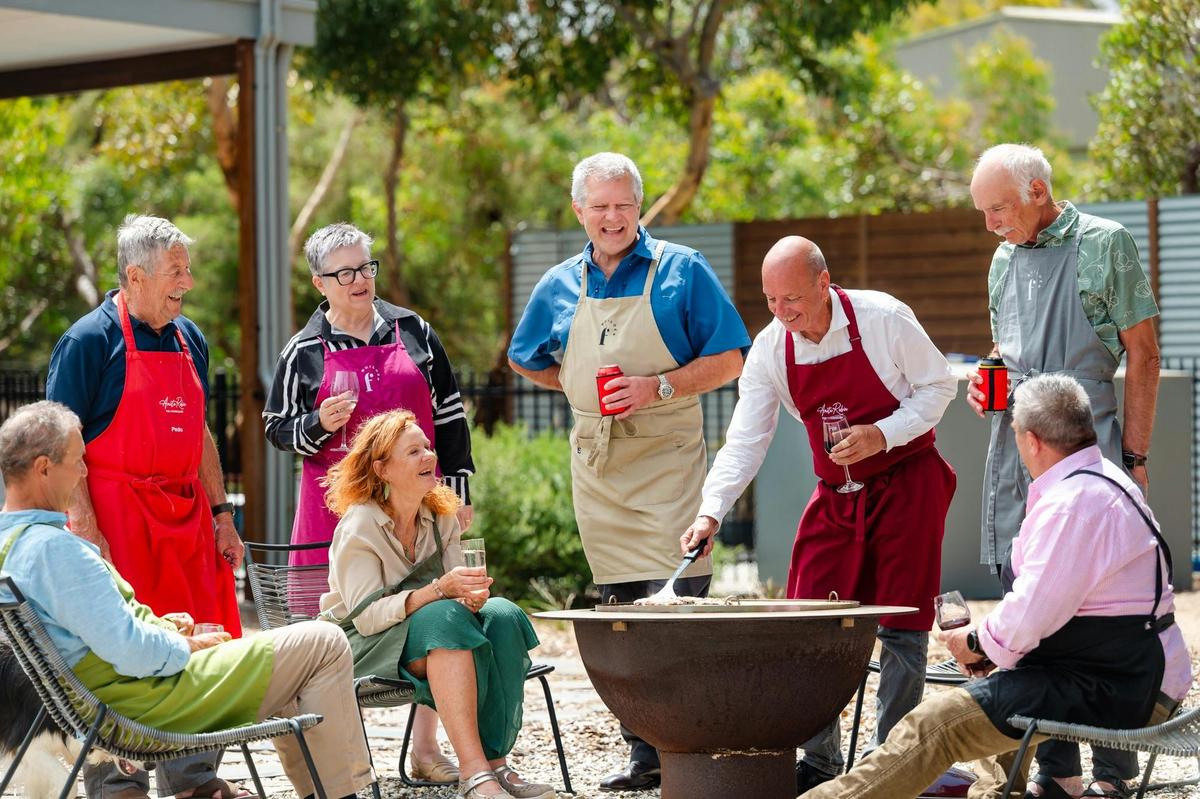 Guests enjoying relaxed outdoor dining around the fire pit after their cooking class