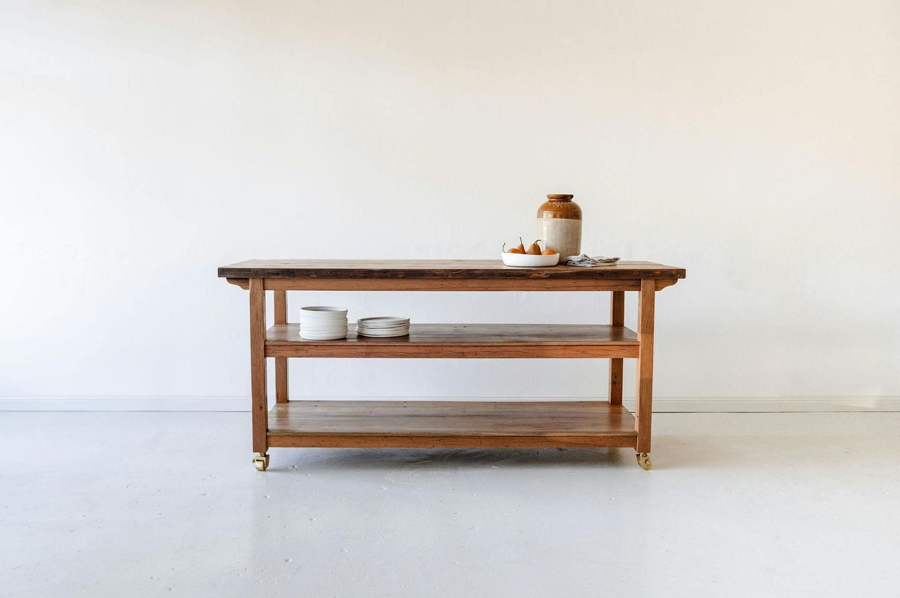 Kitchen island bench made form recycled Australian hardwood with brass castors.