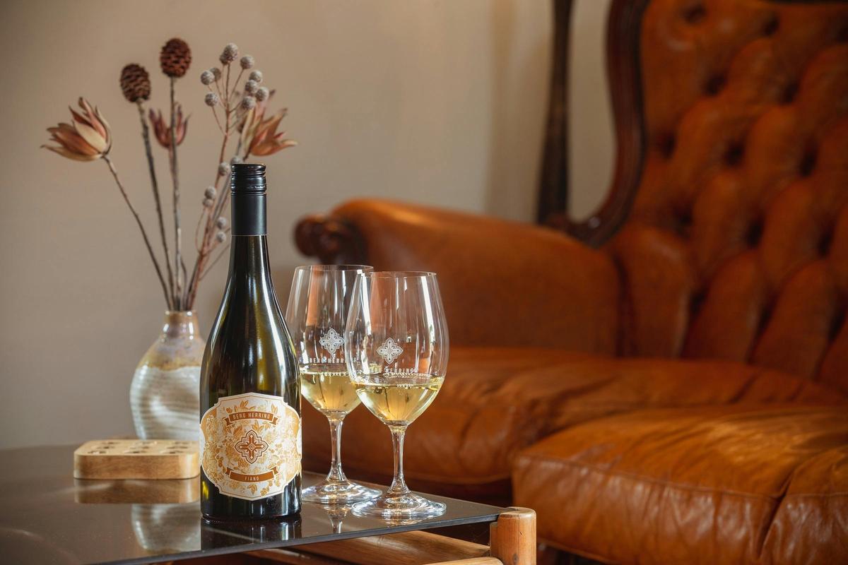 Wine bottle and wine glasses on table in front of antique couch