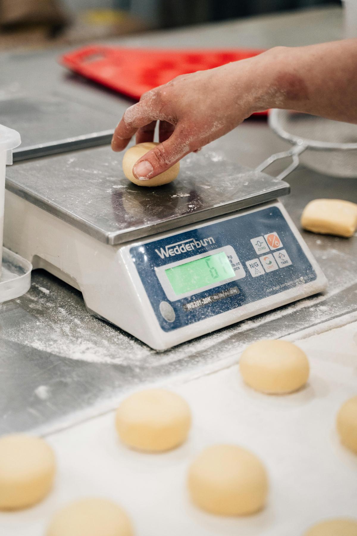 Each donut is weighed out and rolled by hand
