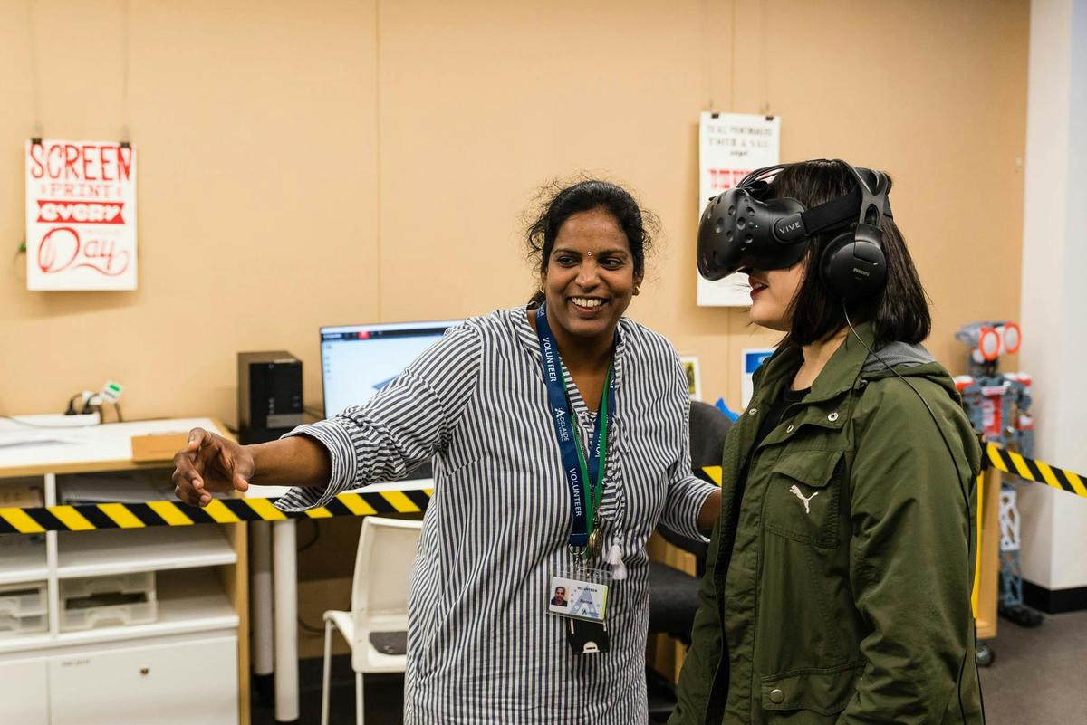 A volunteer assisting a customer with Virtual Reality