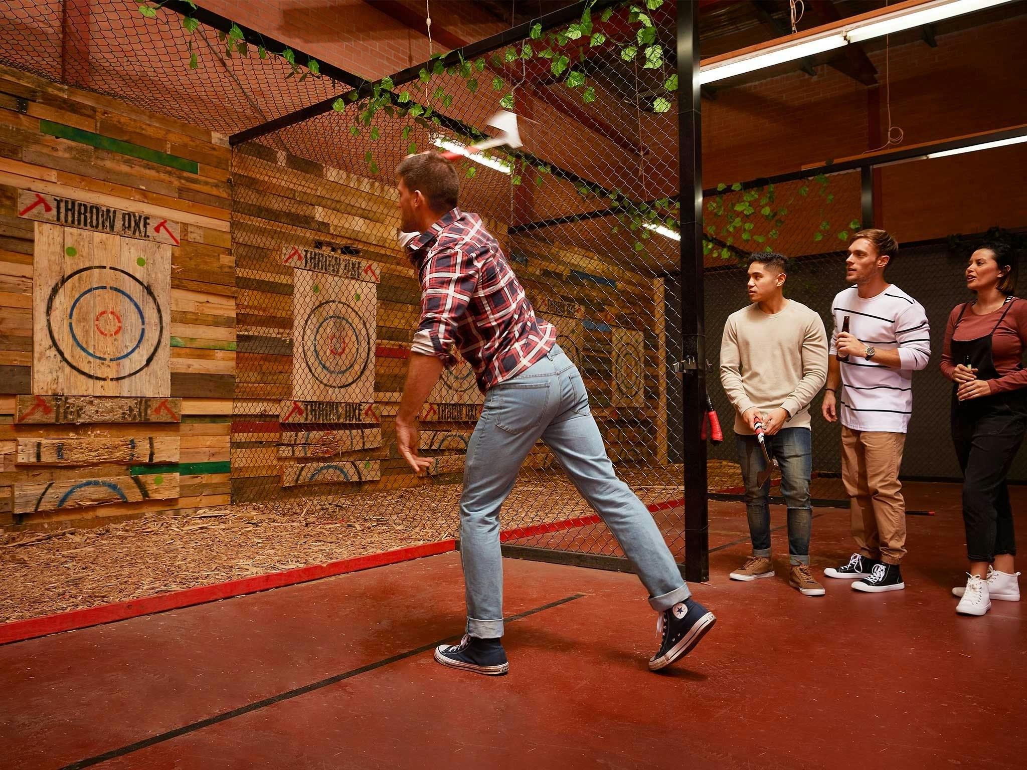 Man throwing axe with specators