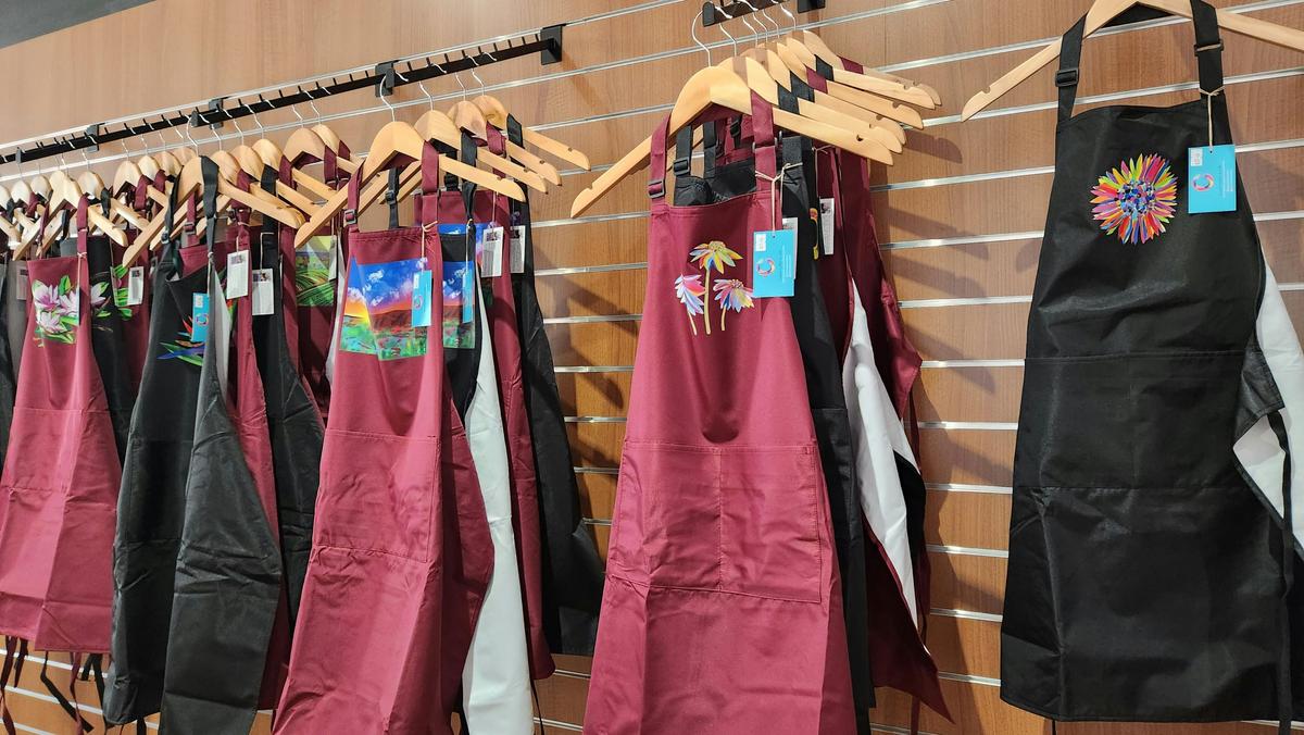 examples of aprons with Grace's colourful designs. Great souvenir!