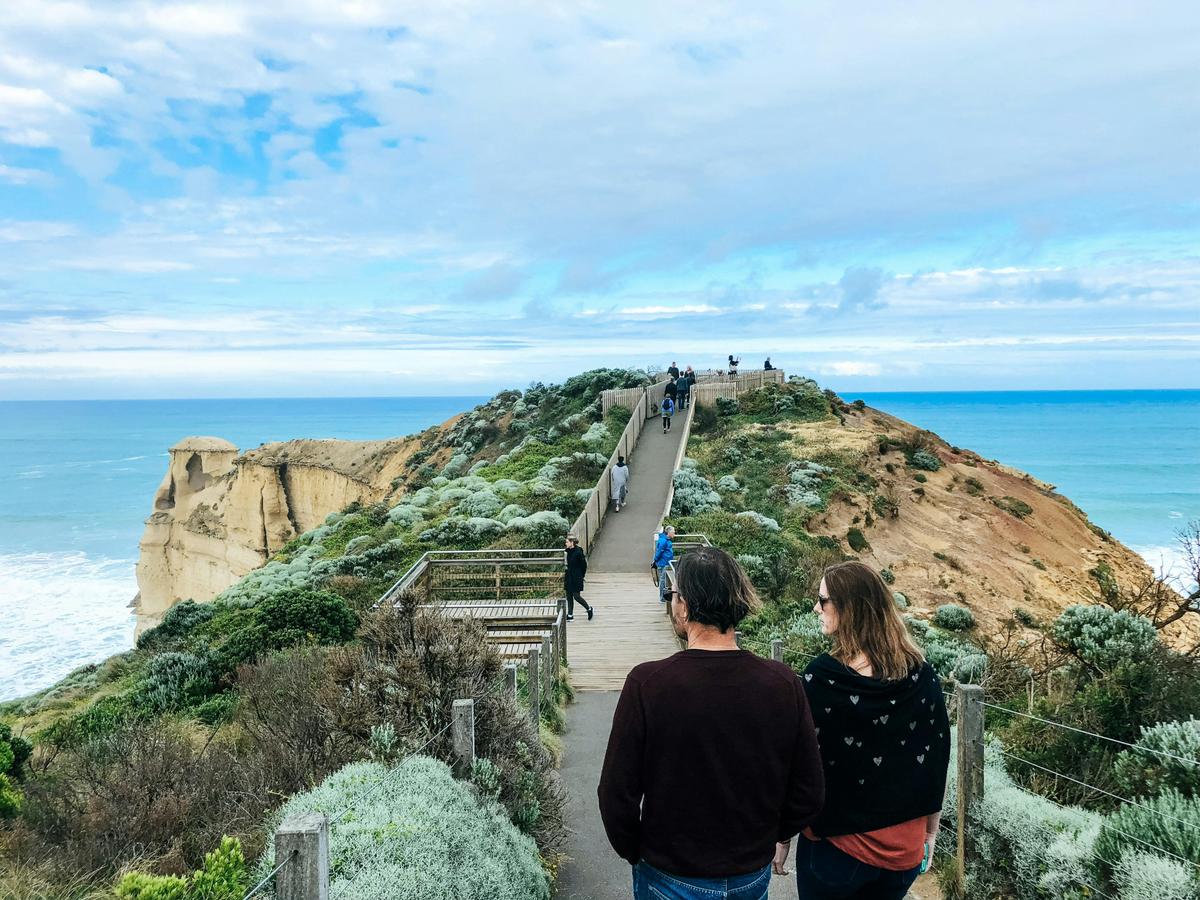 Couple walk along path at the 12 apostles