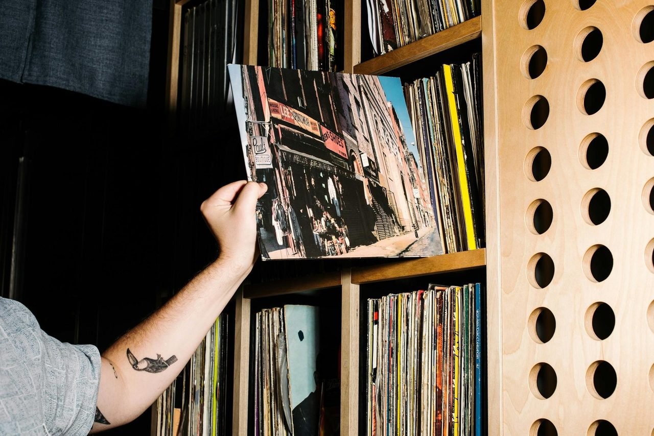 Hand taking vinyl album from shelf